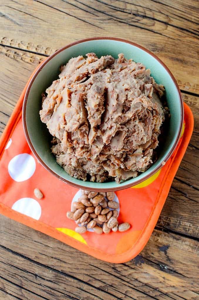 Super easy Homemade Crock Pot Refried Beans Recipe! Perfect for Mexican night, taco night, or burritos! This slow cooker recipe makes family dinners quick and easy to prepare!