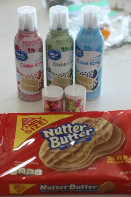 Cake icing cans, sprinkles, and a package of Nutter Butter on a counter