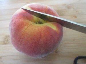 knife cutting into a peach