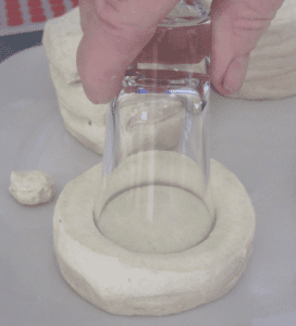 Shot glass cutting a hole in a biscuit