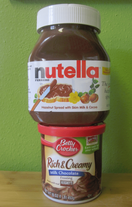 Jar of Nutella on top of a jar of milk chocolate frosting