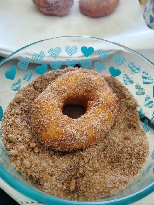 biscuit donut in a bowl of cinnamon sugar