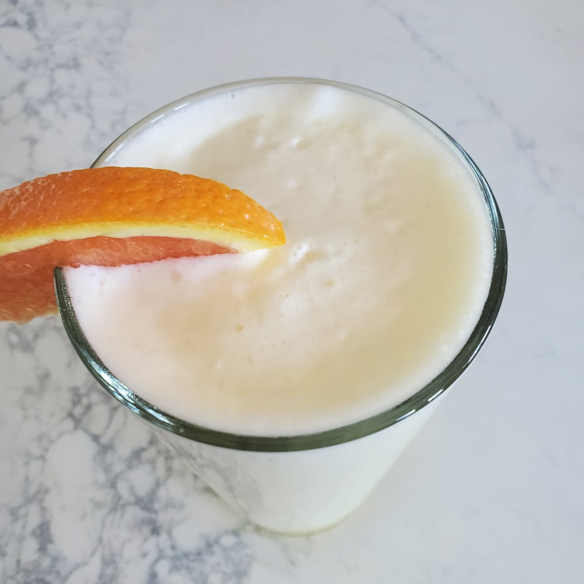 Copy Cat Orange Julius in a tall glass with an orange garnish