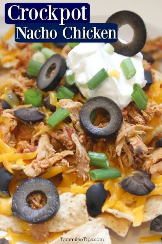 crockpot nacho chicken over chicken, olives, cheese, and sour cream on tortilla chips