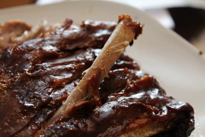 rib sticking out of crockpot ribs on a white platter