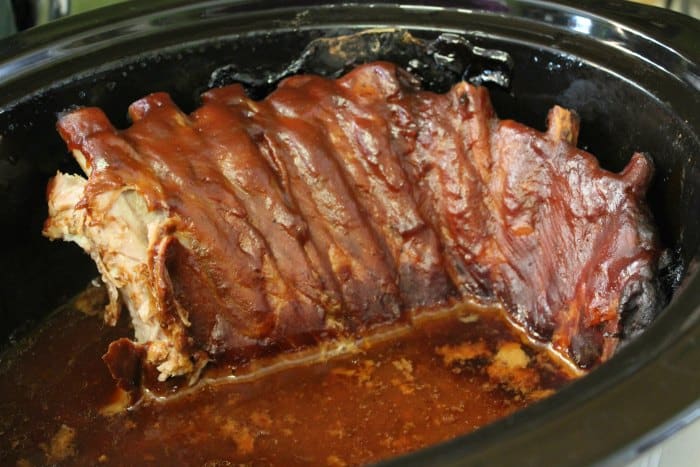 ribs covered in barbecue sauce in a crockpot