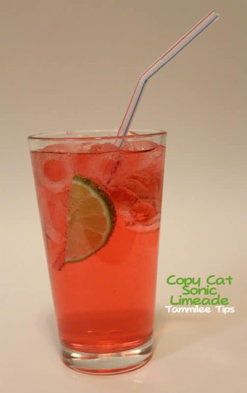 Copycat sonic limeade next to a glass with lime wedge and a straw