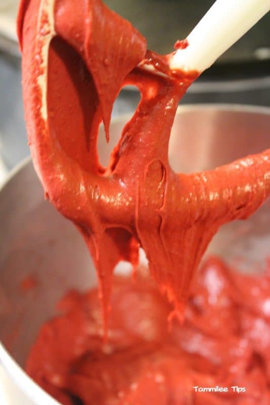 red velvet brownie batter dripping from the mixer attachment