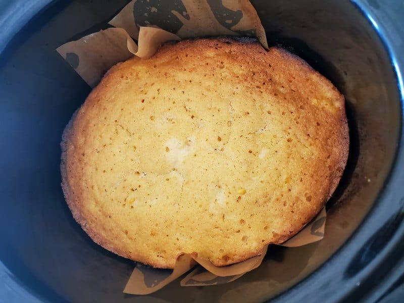 cornbread in a slow cooker bowl with parchment paper