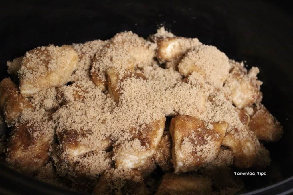 Crockpot Monkey Bread with cinnamon brown sugar over it ready to cook in the slow cooker. 