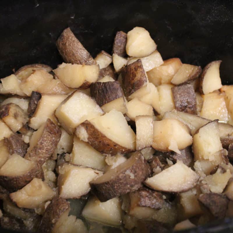 cut up garlic potatoes in a slow cooker bowl