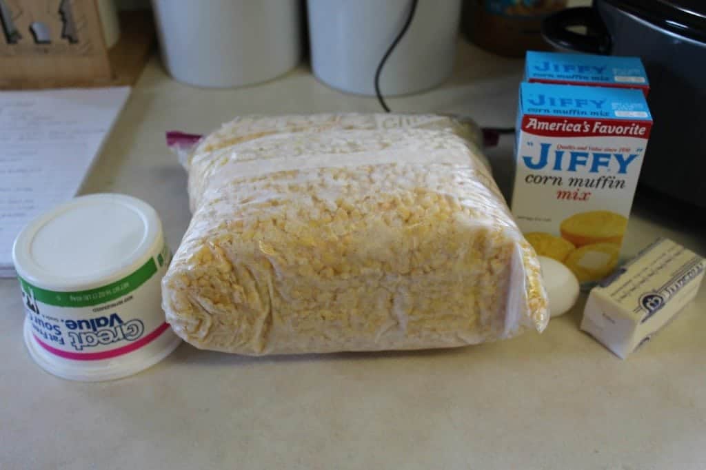 Sour cream, corn, Jiffy cornbread mix, butter, and egg on a white counter