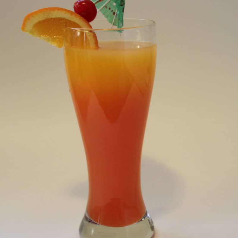 Tequila Sunrise Cocktail in a tall glass with tropical umbrella