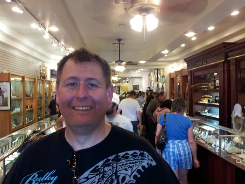 John inside the pawn shop with a crowd of people behind him