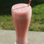 Orange Julius Strawberry Julius in a tall glass with a striped straw