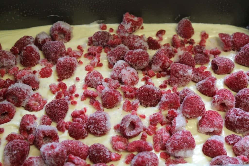 Frozen raspberries on batter in a cake pan