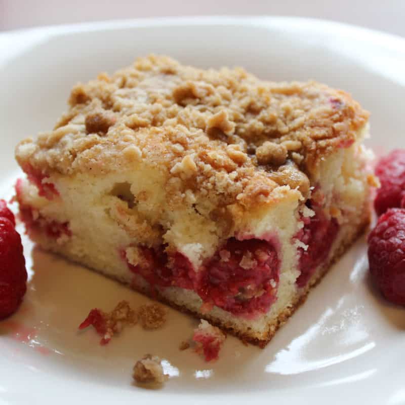 Raspberry Coffee Cake on a white plate with raspberries