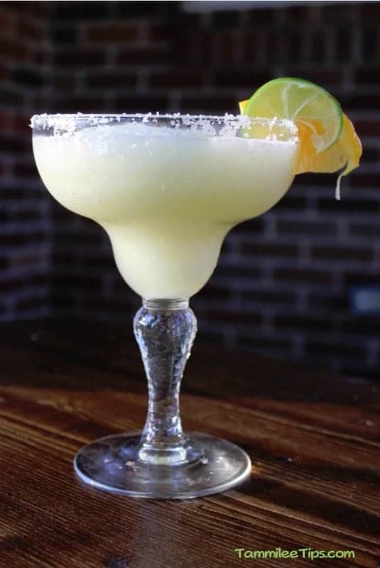 White wine margarita in a classic margarita glass garnished with lime and orange wheel 