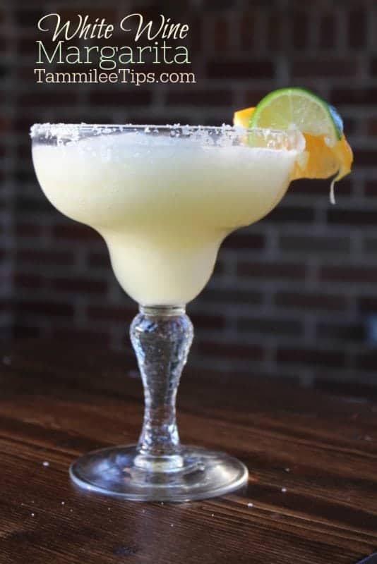 White wine margarita in a classic margarita glass garnished with lime and orange wheel 