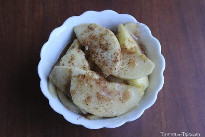 Boston Market Apples with cinnamon in a white bowl on a wood background. 