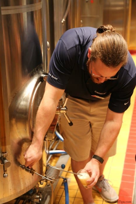 Carnival employee pouring beer from a large cask