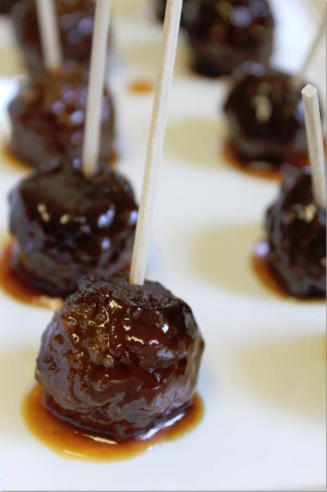 Grape Jelly Meatballs on a white platter with toothpicks