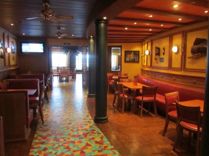 Tables and chairs next to tropical decor and a colorful tile floor