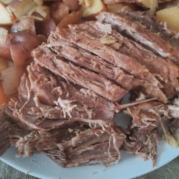 Alaskan Amber Crock Pot Roast on a white platter with potatoes