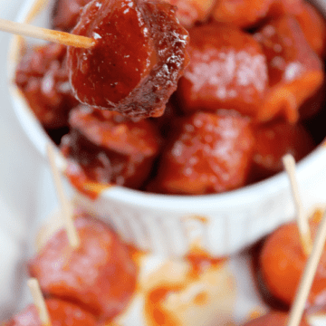 Spicy barbecue kielbasa in a bowl with one piece on a toothpick