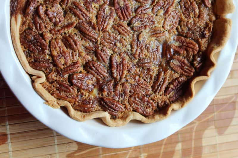 pumpkin pecan pie in a white pie dish