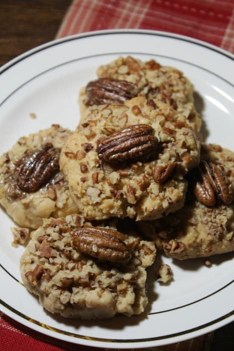 Butter pecan cookies on a white plate sitting on a red napkin