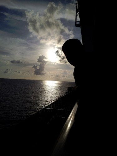 Carnival Breeze Balcony Sunset with john leaning over the balcony