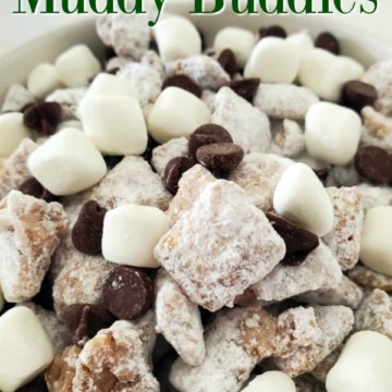 Hot Chocolate muddy Buddies text over a white bowl with mini marshmallows, mini chocolate chips and cereal