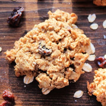 Oatmeal Raisin Cookies with oats and raisins on a wood board