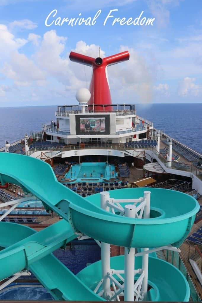 Carnival Freedom text over the lido deck with waterslides, pool, and carnival funnel