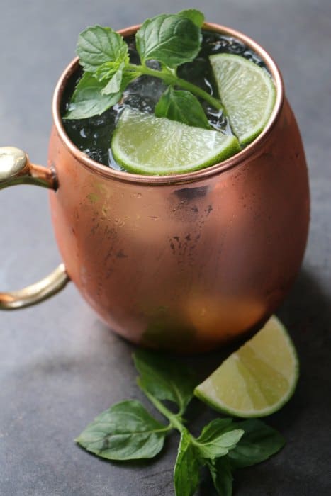 Moscow Mule drink in a copper mug with mint and lime wedge garnish
