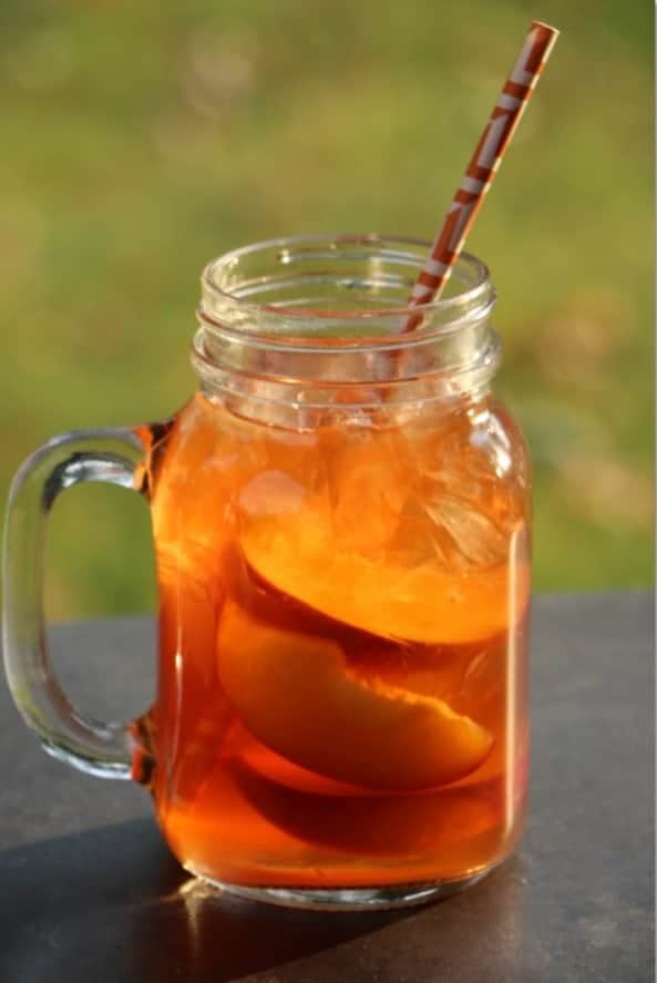 Peach Iced Tea Cocktail in a mason jar glass with paper straw