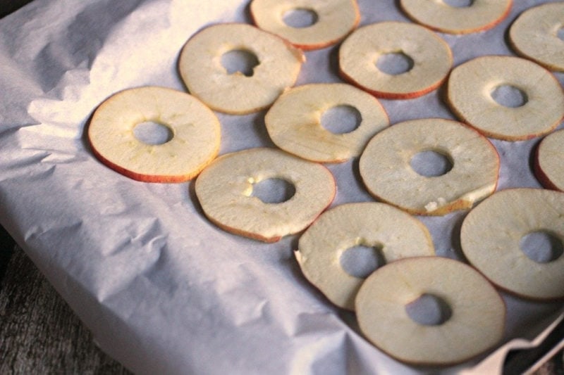 apple slices on parchment paper before drying