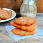 Cinnamon And Sugar Crescents stacked on a paper napkin near a plate and sugar container