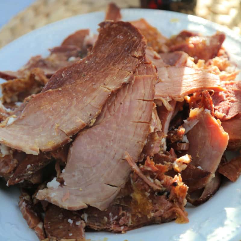 slices of crockpot coke ham on a white platter