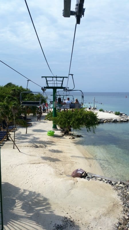 Ski lift with people riding over the beach