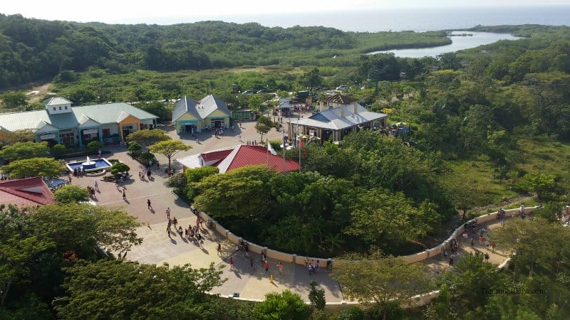 looking down on buildings and tropical plants with people walking a long pathway