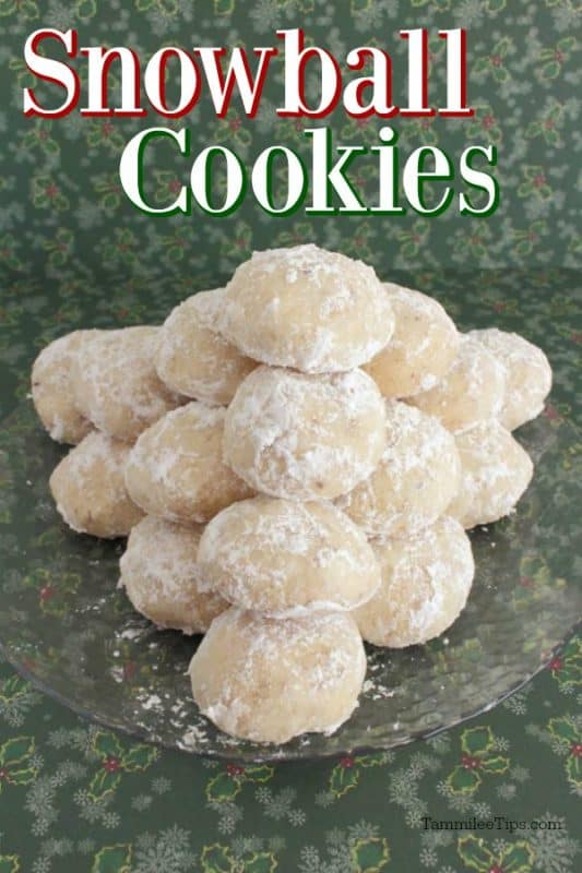 Snowball Cookies over a glass plate with cookies stacked on it