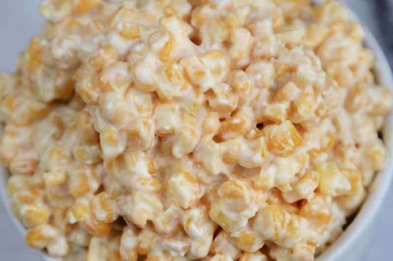 Close up of crockpot creamed corn in a white bowl 