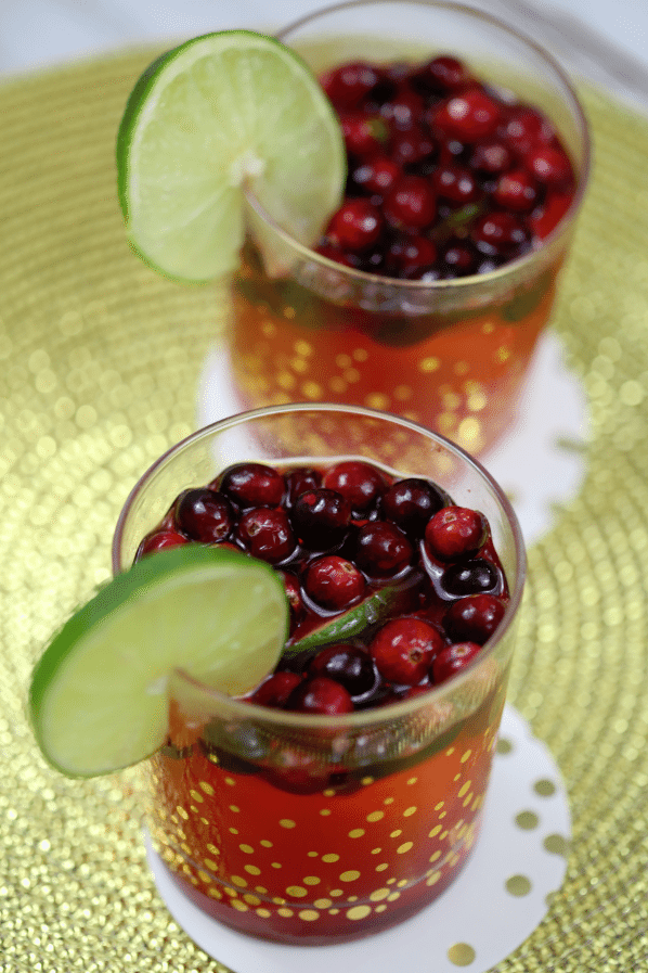 Cranberry Lime Cocktail in gold polka dot glasses with a lime wheel