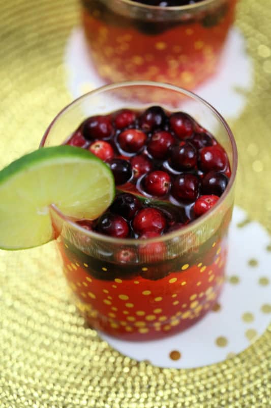 cranberry and lime cocktail in a gold dotted glass