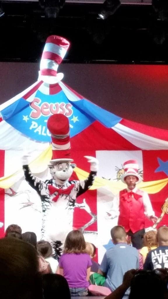 Cat in the hat character in front of kids on stage with seuss-a-palooza tent