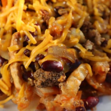 french fry casserole with kidney beans and cheese on a white plate