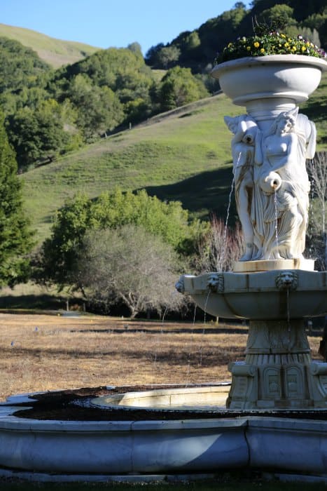 Artistic white fountain with rolling hills in the background