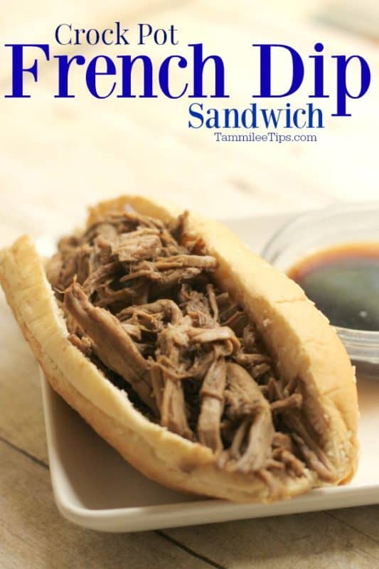 Crockpot French Dip Sandwich over a white plate with a French Dip sandwich in a bun next to a bowl of Au Jus sauce